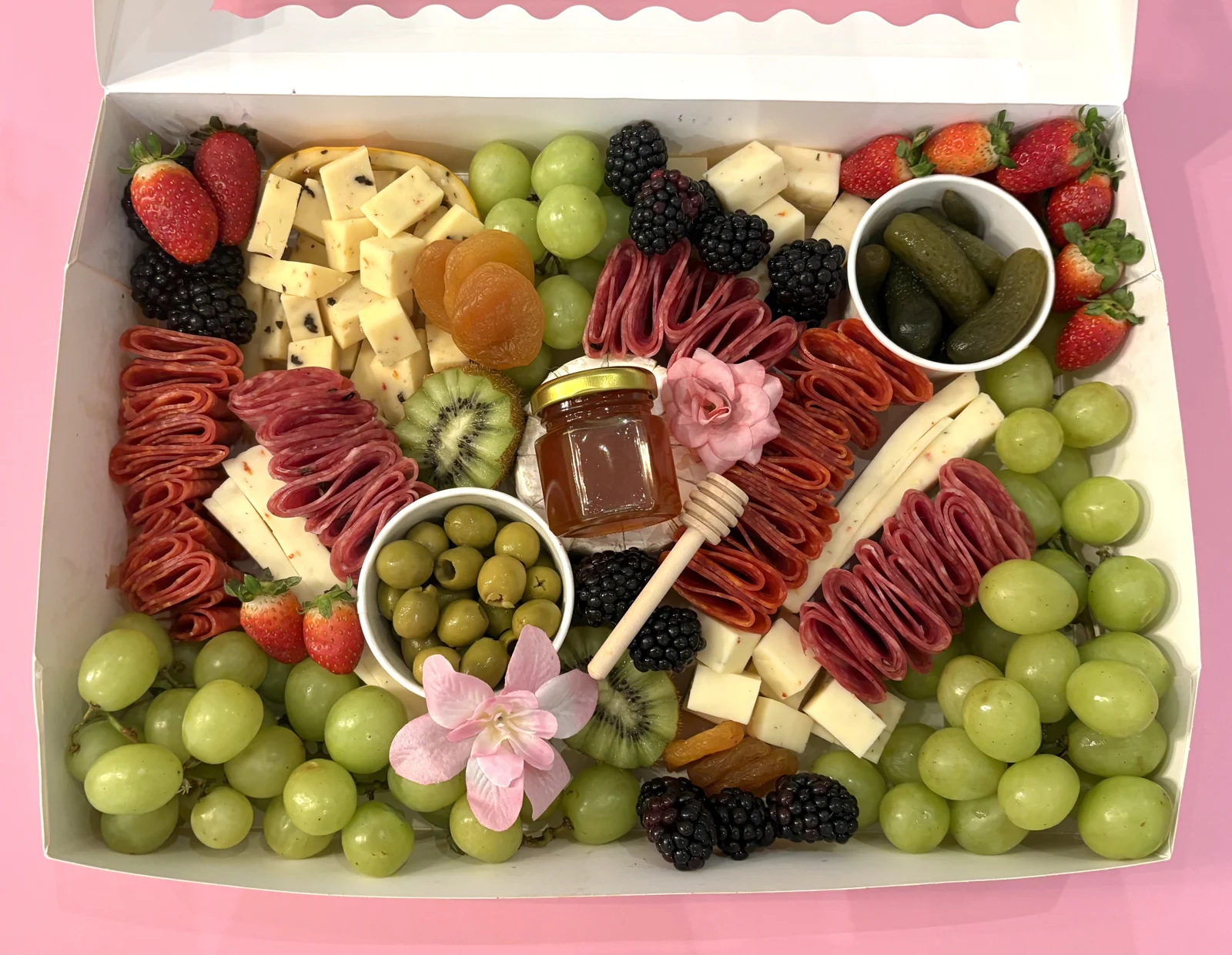 Charcuterie box filled with cheese, cured meats and fruit