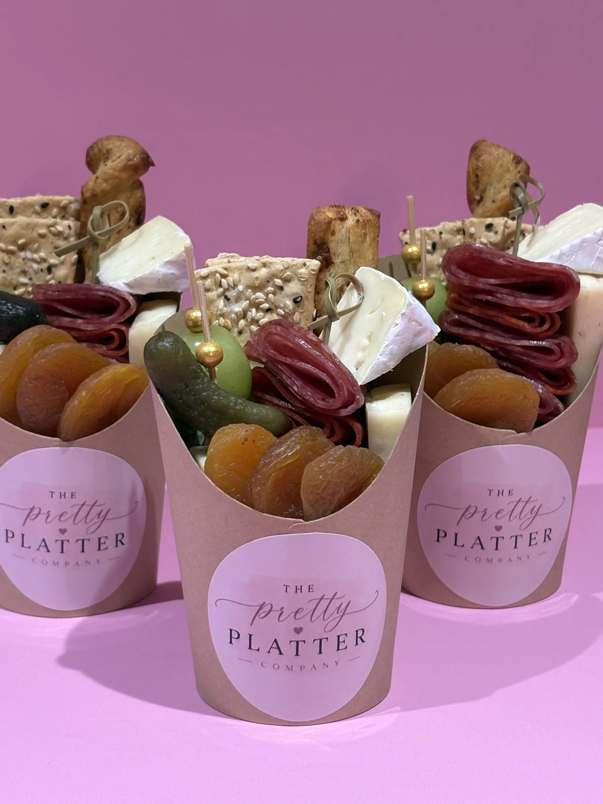 Individual charcuterie cups with crackers, cheeses and cured meats