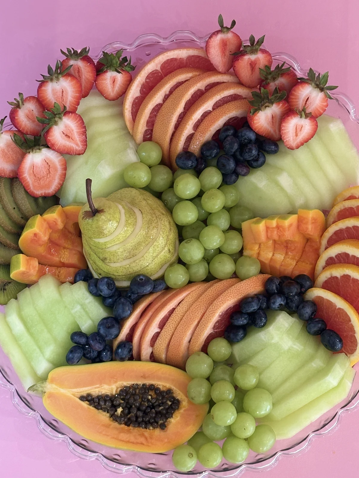 Colourful tray of sliced fruit and fresh berries